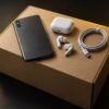 無地の段ボール箱と古いスマートフォンとイヤホンとケーブル