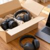 開いた段ボール箱とカメラ、ノートパソコン、ヘッドホンが並ぶテーブル